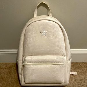 Cream colored Jeffree Star faux alligator backpack with red crossbody canvas bag